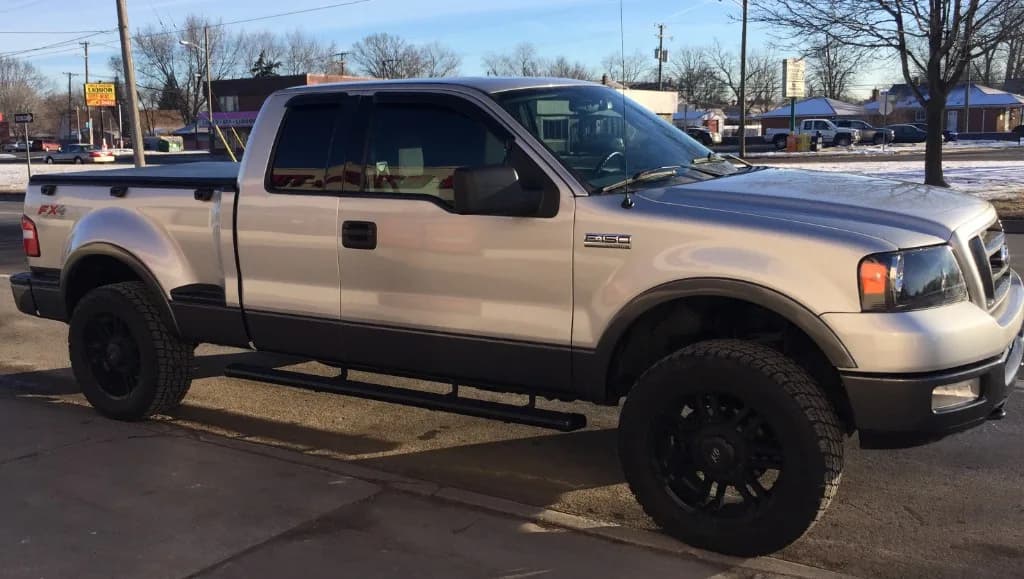 Silver Ford F-150 FX4 with black custom wheels and all-terrain tires — same-day install